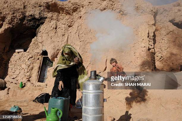 Khadija makes tea for her children near a cave dwelling in Bamiyan on November 10, 2009. The cave dwellers are all Hazara, who are religiously and...