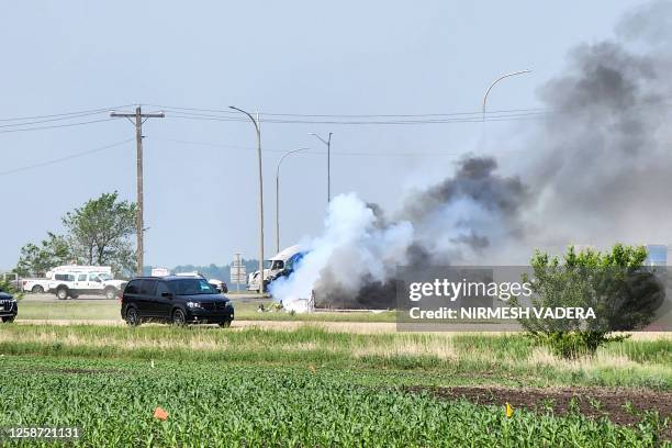 Smoke comes out of a car following a road accident that left 15 dead near Carberry, west of Winnipeg, Canada on June 15, 2023. At least 15 people...