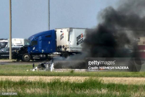 Smoke comes out of a car following a road accident that left 15 dead near Carberry, west of Winnipeg, Canada on June 15, 2023. At least 15 people...
