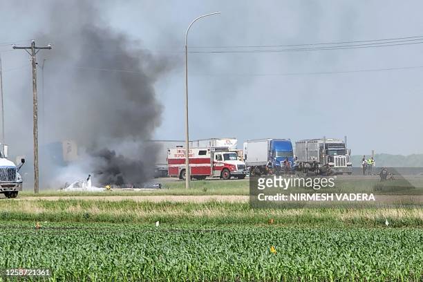 Smoke comes out of a car as first responders are pictured following a road accident that left 15 dead near Carberry, west of Winnipeg, Canada on June...