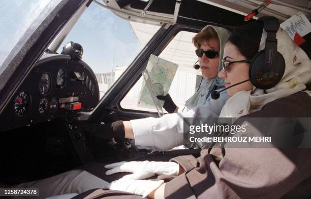 Iranian co-pilot and instructor Nahid Qafarian carries out a pre-flight test 01 June 2001 in the cabin of a German-made Ikarus C-42 light plane,...