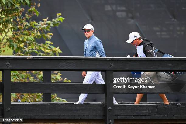 Rickie Fowler walks with his caddie Ricky Romano across the bridge to the ninth hole green during the first round of the 123rd U.S. Open Championship...