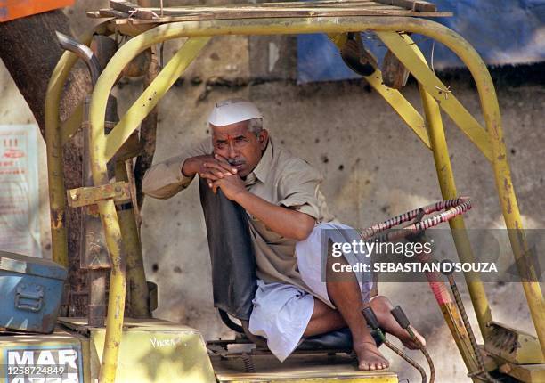 Port worker seated on a forklift daydreams outside the gate of the port of Bombay 19 January 2000 as the strike by some 100,000 workers across 11...