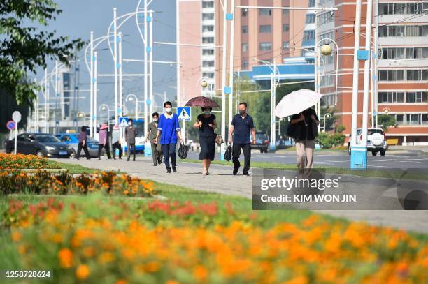 Pedestrians walk along Mirae Scientists' Street in Pyongyang on June 16, 2023.
