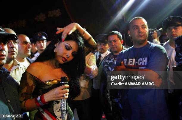 Lebanese pop star Haifa Wehbe is surrounded by bodyguards after dispersing the crowds from the stage during her performance in downtown Beirut as...