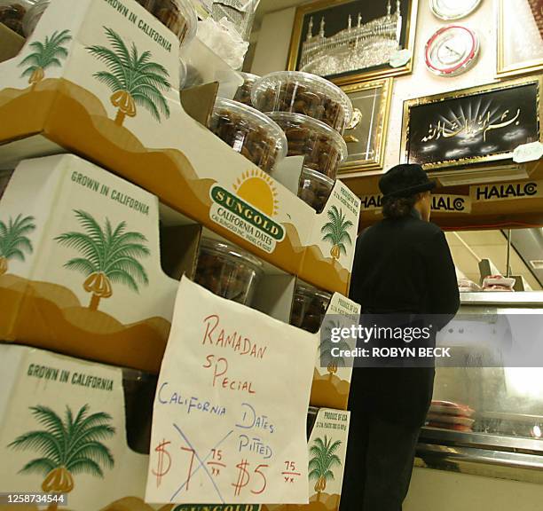 Shopper waits to purchase meat at the butcher counter of a halal food shop 05 November 2002 in Falls Church, Virginia, as American Muslims prepare...