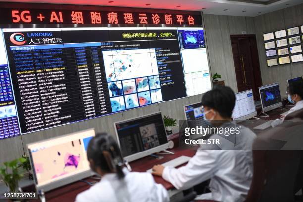 This photo taken on June 15, 2023 shows laboratory technicians conducting artificial intelligence -based cervical cancer screening at a test facility...