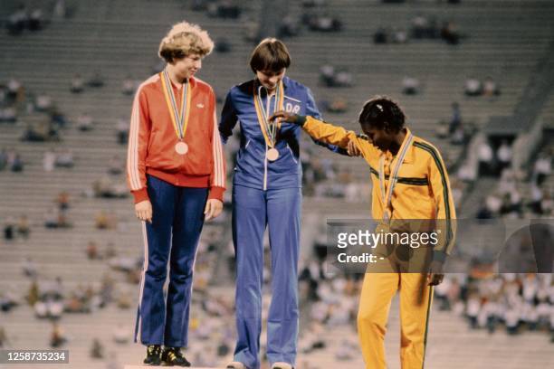 Second-placed USSR's Natalya Bochina, first-placed East German sprinter Barbel Wockel and third-placed Jamaica's Merlene Ottey, stand on the podium...