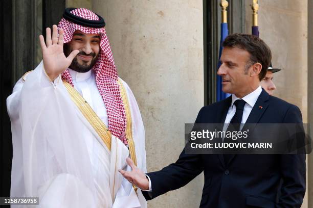 France's President Emmanuel Macron greets Saudi Crown Prince Mohammed bin Salman as he arrives at presidential Elysee Palace in Paris, on June 16,...