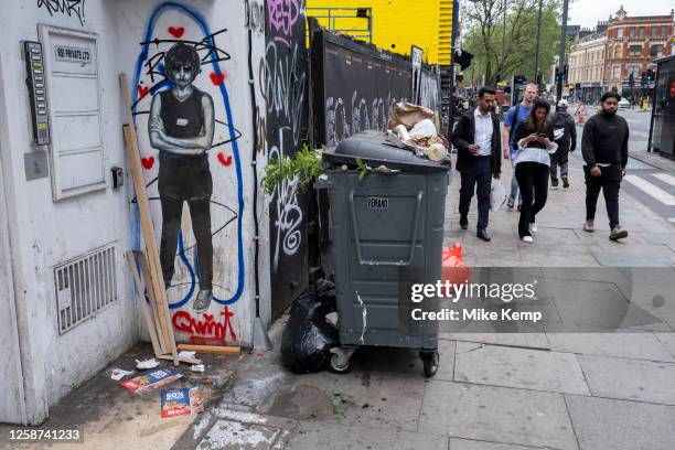 Litter piled up on top of commercial waste collection rubbish and recycling bin along Whitechapel High Street on 25th May 2023 in London, United...