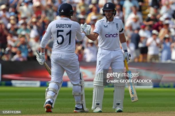 England's Joe Root congratulates England's Jonny Bairstow on reaching his half century during play on the opening day of the first Ashes cricket Test...