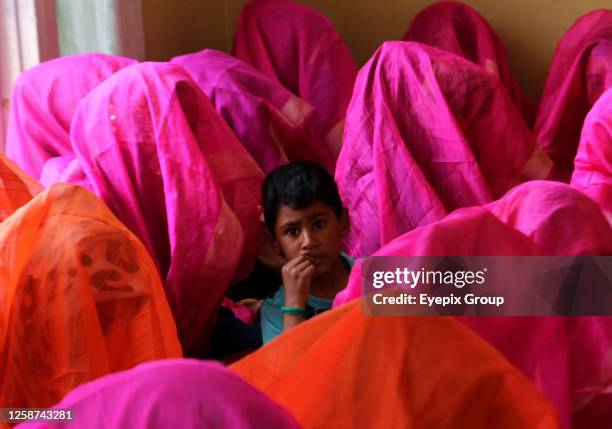 June 15 Srinagar Kashmir, India: A child looks on as Muslim brides gather in a room during a mass marriage event in Srinagar. At least 61 sets of...