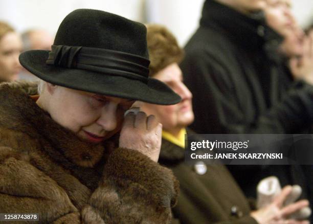 Woman cries during a mass dedicated to the victims who died when an exhibition hall roof collapsed the day before, 29 January 2006, in Chorzow. At...