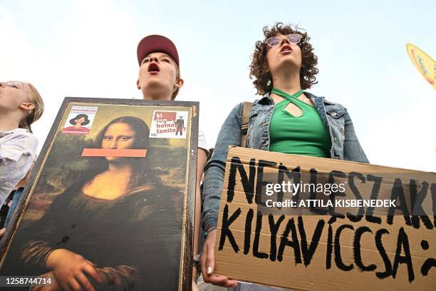 Students hold signs as they protest outside the parliament in Budapest on June 16 during their joint demonstration against the Hungarian government's...