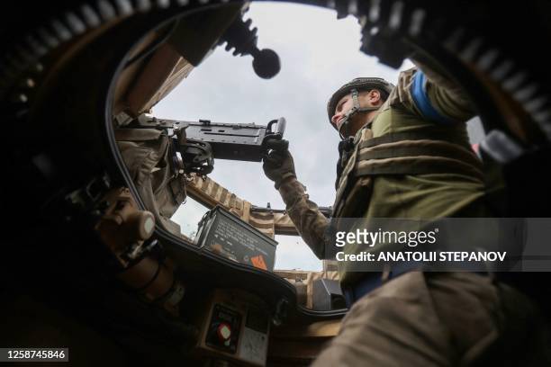 Ukrainian serviceman mans a machine gun as he rides on a MaxxPro MRAP in the recently liberated village of Blagodatne, Donetsk region on June 16 amid...