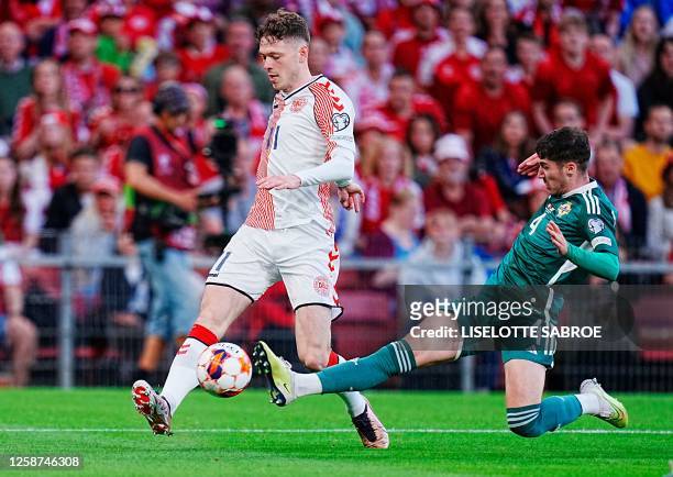 Denmark's forward Andreas Skov Olsen and Northern Ireland's midfileder Trai Hume vie for the ball during the UEFA Euro 2024 group H qualification...