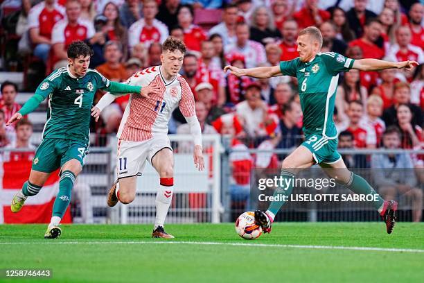 Northern Ireland's midfileder Trai Hume, Denmark's forward Andreas Skov Olsen and Northern Ireland's midfielder George Saville vie for the ball...