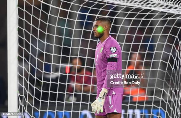 Athens , Greece - 16 June 2023; A laser is seen shining on the face of Republic of Ireland goalkeeper Gavin Bazunu as he prepares for a penalty from...