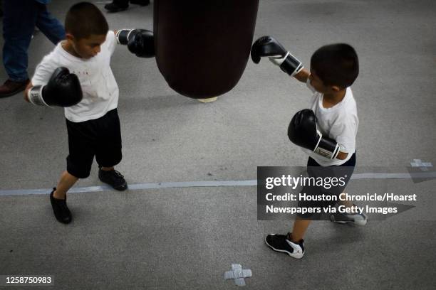 Daniel Figueroa left, and his twin brother Jonathan Figueroa, right, work on a punching bag during a workout at the Savannah Boxing Club on Tuesday,...