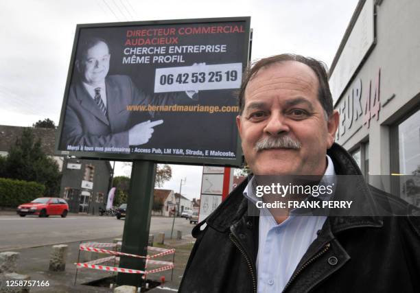 Bernard Mauriange, un chomeur de 53 ans, pose au pied de l'affiche publicitaire qui le met en scène et doit l'aider à retrouver un emploi, le 06...