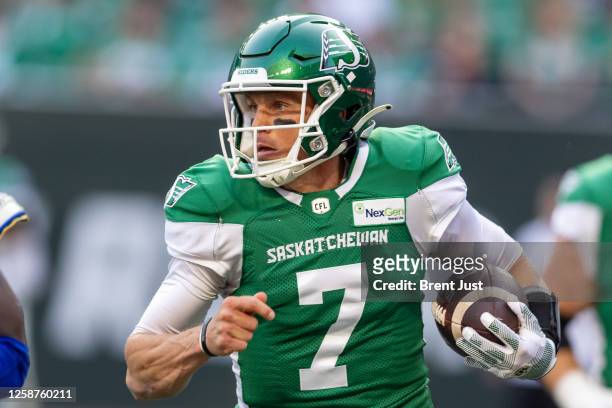 Trevor Harris of the Saskatchewan Roughriders scrambles with the ball in the first half of the game between the Winnipeg Blue Bombers and...