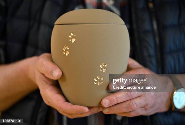 June 2023, Thuringia, Hainichen: Jürgen Herfurth presents an urn for an animal's ashes at the "Resting place for small animals - Hainichen animal...