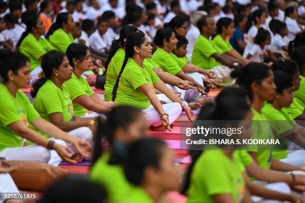 Practitioners take part in a mass yoga session organized by the Indian High Commission Office at Independence square in Colombo on June 17 ahead of...