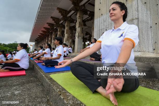 Practitioners take part in a mass yoga session organized by the Indian High Commission Office at Independence square in Colombo on June 17 ahead of...