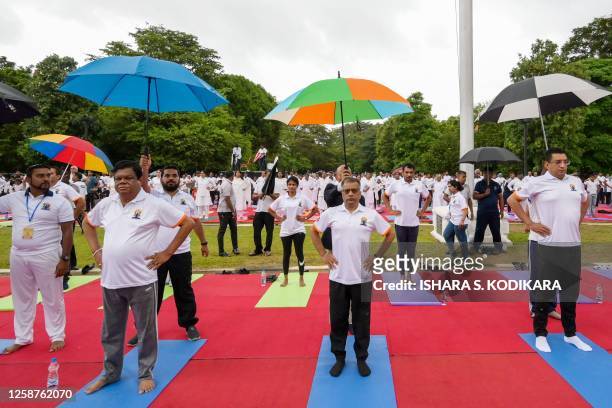 Practitioners take part in a mass yoga session organized by the Indian High Commission Office at Independence square in Colombo on June 17 ahead of...
