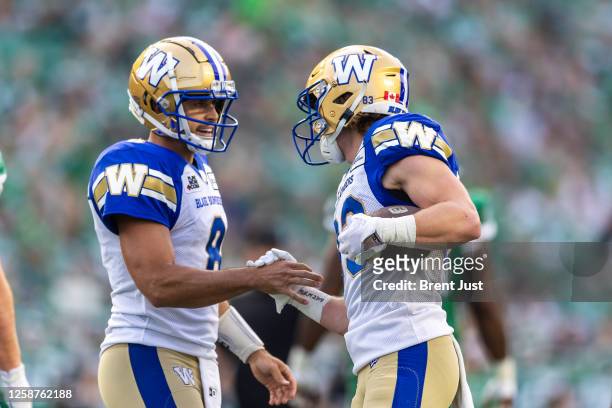 Zach Collaros congratulates Dalton Schoen of the Winnipeg Blue Bombers after a touchdown in the game between the Winnipeg Blue Bombers and...