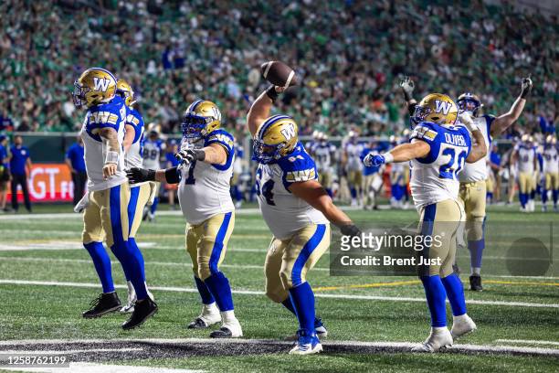 Liam Dobson of the Winnipeg Blue Bombers spikes the ball to celebrate after a touchdown in the game between the Winnipeg Blue Bombers and...
