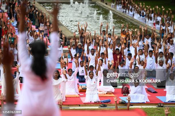 Practitioners take part in a mass yoga session organized by the Indian High Commission Office at Independence square in Colombo on June 17 ahead of...