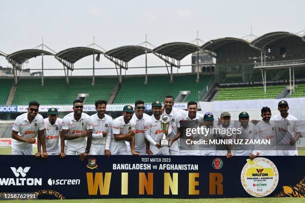 Bangladesh cricketers pose with the trophy after winning on the fourth day of play the Test cricket match between Bangladesh and Afghanistan at the...