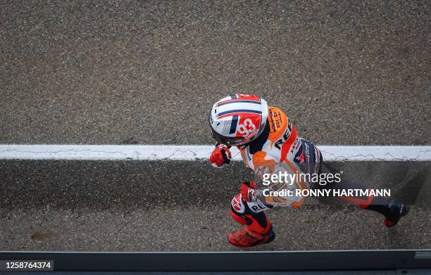 Repsol Honda Team's Spanish rider Marc Marquez runs back to his box after crashing during the qualifying session for the MotoGP German motorcycle...