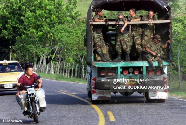 Colombian government troops travel along a highway near the town of Puerto Rico on their way to the demilitarized rebel-held territory of the...