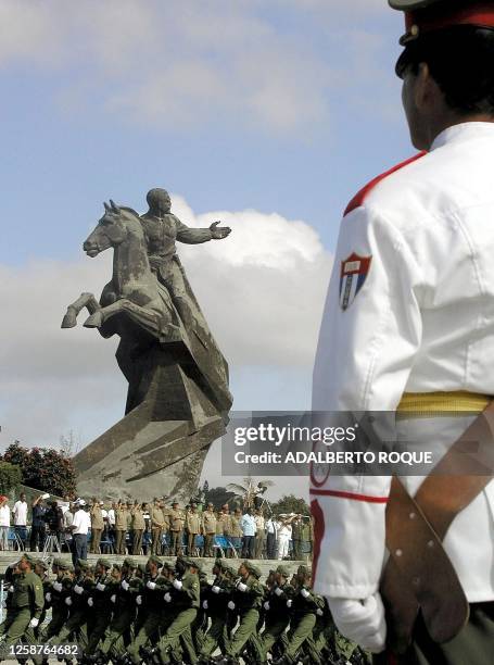 Soldiers are seen celebrating the 45th anniversary of the arrival of the yacht Granma 02 December 2001. Soldados pasan frente a la estatua del procer...