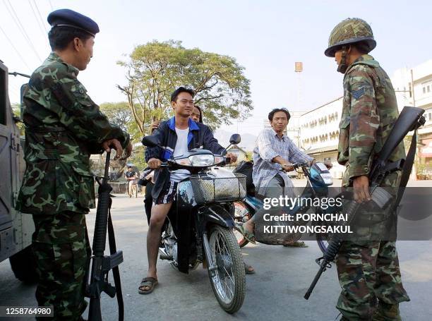 Two Thai soldiers wait on security duty at the Thailand-Myanmar border in Mae Sai district Chiang Rai, 11 February 2001. Fighting between Myanmar and...