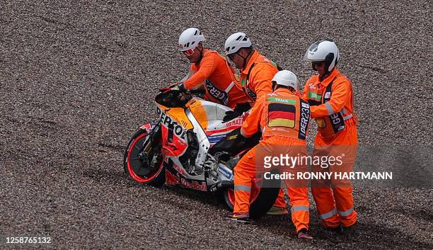The motorbike of Repsol Honda Team's Spanish rider Marc Marquez is pushed out of the gravel by track marshals during the qualifying session for the...