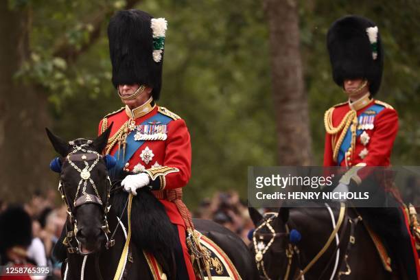 Britain's King Charles III and Britain's Prince William, Prince of Wales ride their horses as they parade down The Mall after leaving Buckingham...