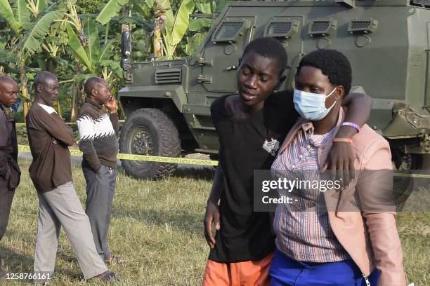 Boy is conforted at the scene of an attack in Mpondwe, Uganda, on June 17, 2023 at the Mpondwe Lhubiriha Secondary School. The death toll from an...