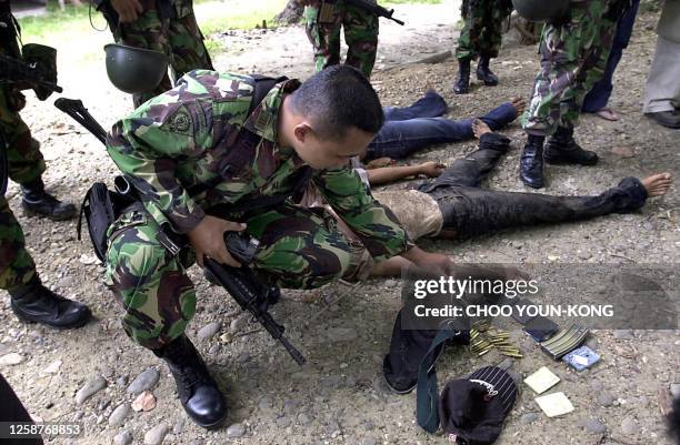 Indonesian troops check the bodies of suspected Free Aceh Movement rebels after they were shot in Lhokseumawe, Aceh province, 25 May 2003. A series...