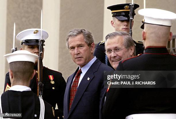 President George W. Bush and Secretary of Defense Donald Rumsfeld walk past a Honor Guard cordon on the steps of the Pentagon 02 December 2002 after...