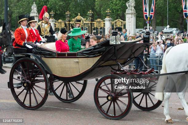 Queen Camilla , Catherine, Princess of Wales, and Princess Charlotte travel in a horse-drawn carriage along The Mall during Trooping the Colour...