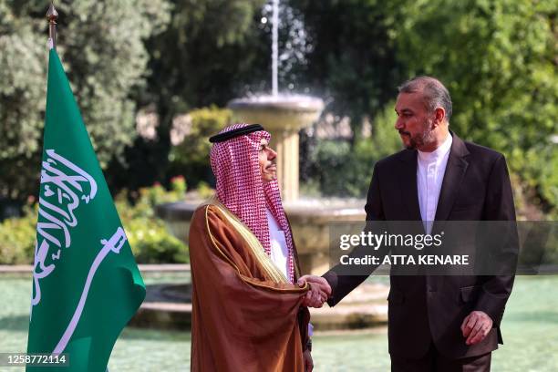 Iran's Foreign Minister Hossein Amir-Abdollahian shakes hands with his Saudi counterpart Faisal bin Farhan in Tehran on June 17, 2023.