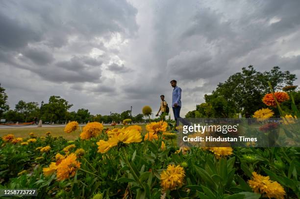 People out in summer day on a cloudy afternoon near India Gate Lawn on June 17, 2023 in New Delhi, India. The India Meteorological Department had...