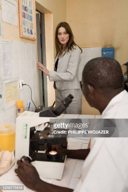 France's first lady Carla Bruni-Sarkozy talks with a technician as she visit an HIV virus blood testing laboratory at the Pissy medical center in...