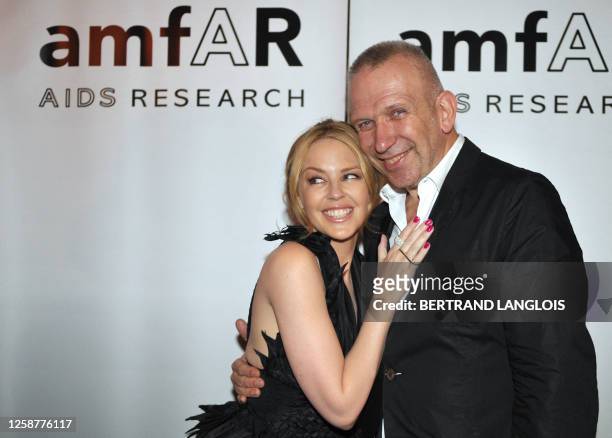 French designer Jean-Paul Gaultier and Australian singer Kylie Minogue pose as they arrive to take part in a charity auction for the American...