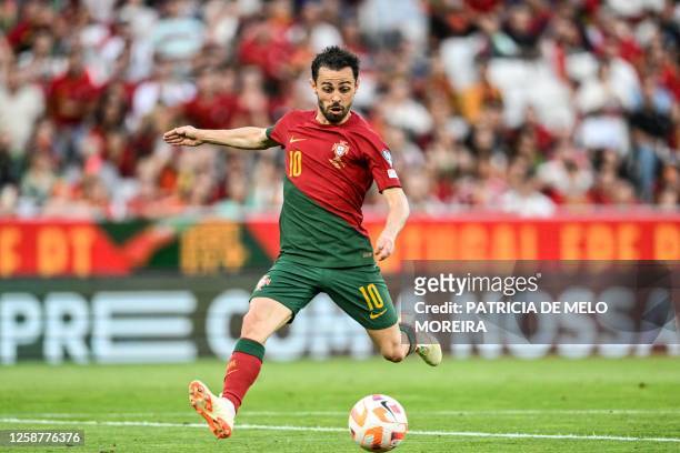 Portugal's midfielder Bernardo Silva kicks the ball and scores his team's first goal during the UEFA Euro 2024 group J qualification football match...