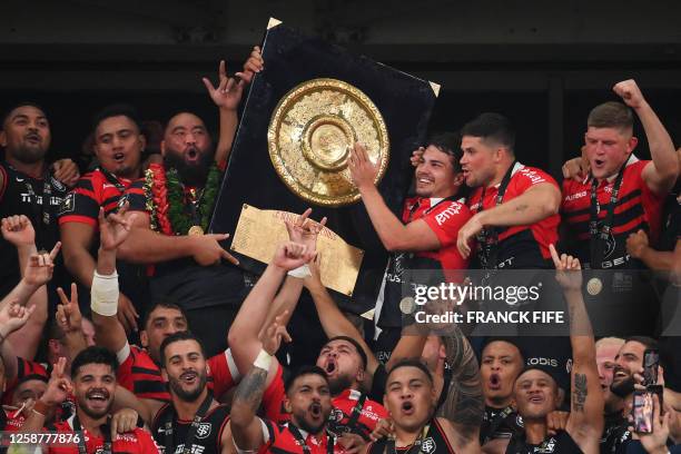 Toulouse's New Zealand prop Charlie Faumuina and Toulouse's French scrum-half Antoine Dupont celebrate holding the Bouclier de Brennus trophy after...