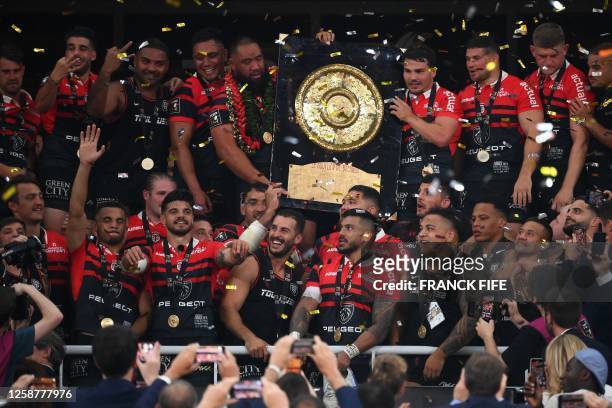 Toulouse's New Zealand prop Charlie Faumuina and Toulouse's French scrum-half Antoine Dupont celebrate holding the Bouclier de Brennus trophy after...